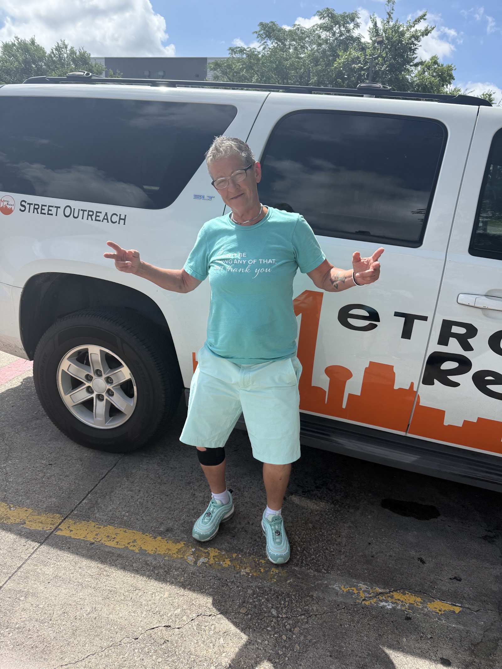 Donica smiling in front of a Metro Relief street outreach vehicle
